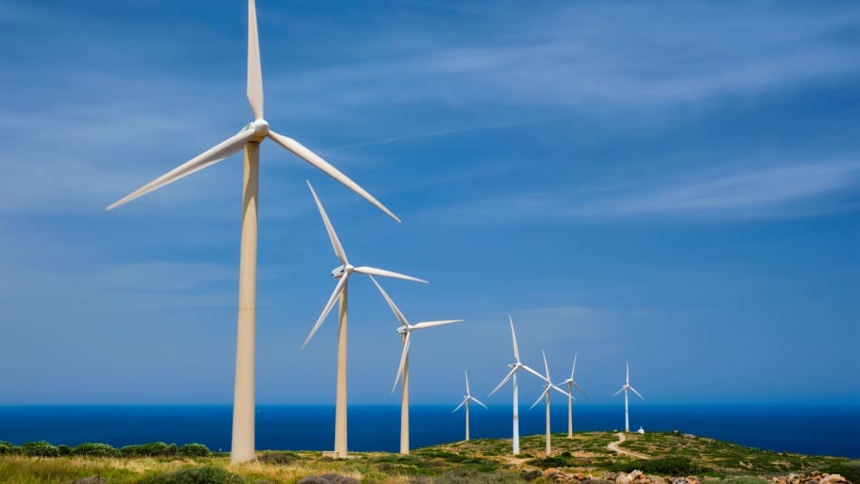 Multiple wind turbines on an island overlooking the ocean